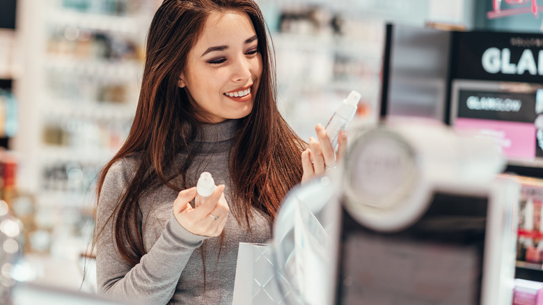 Woman shopping for cosmetics in retail store