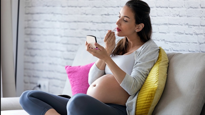 pregnant woman doing makeup 