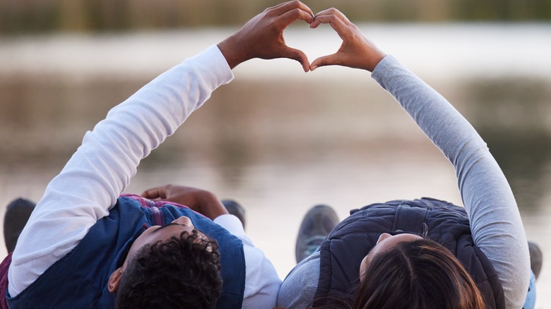 couple making a heart with their hands