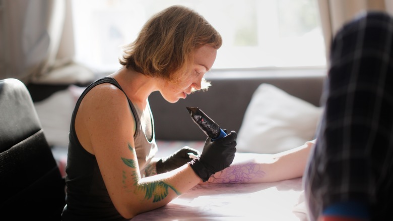 woman using tattoo gun
