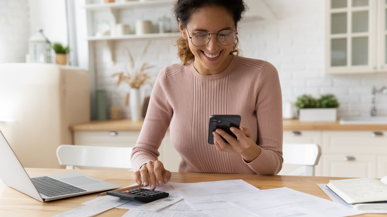 Woman happily budgeting in kitchen