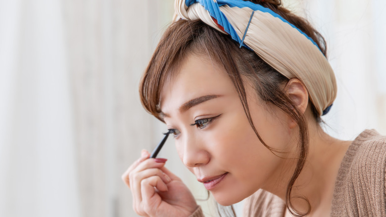 woman using eyeliner