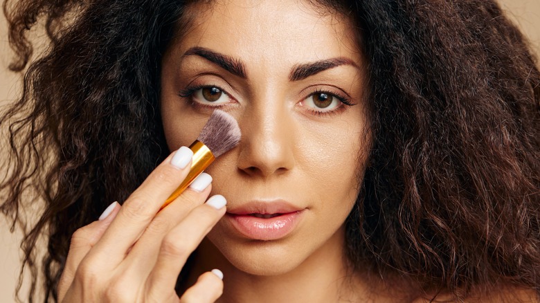 Woman applying undereye powder 