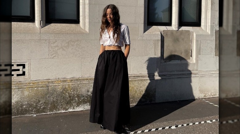 Woman pairing maxi skirt, crop top