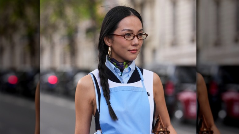 A woman on the street wears her hair in a side braid