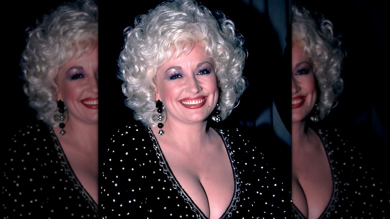 Dolly Parton in 1984 wearing a black top embellished with rhinestones.