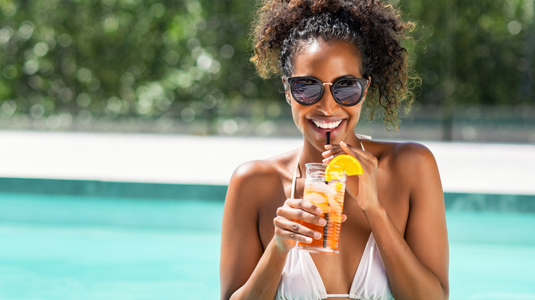 woman with drink in pool