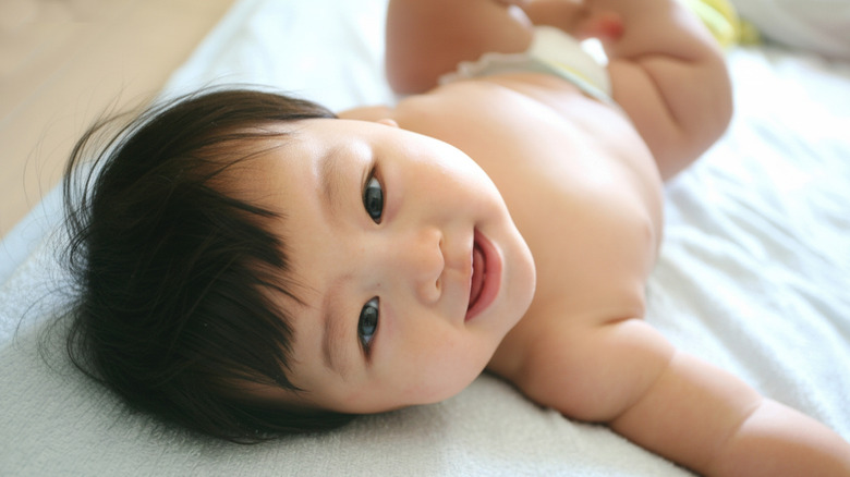 A baby smiling at the camera