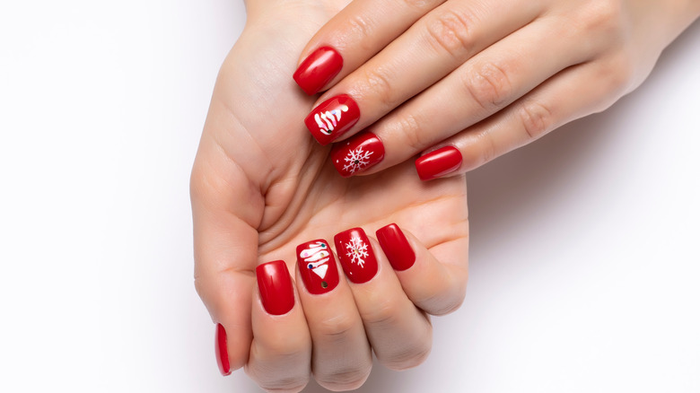Red holiday manicure with snowflakes and trees