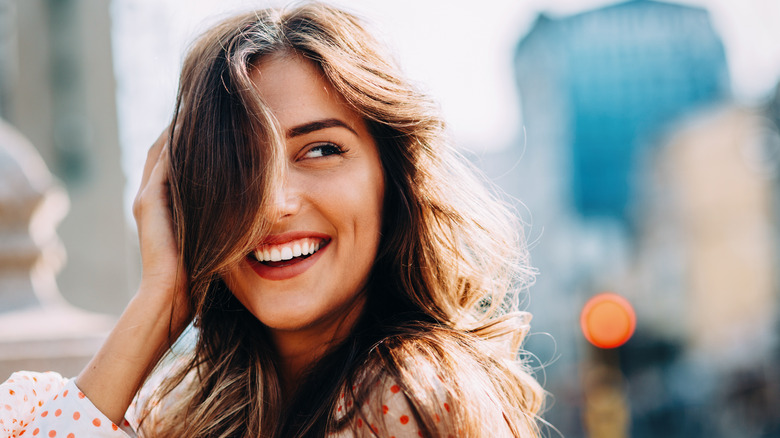 Woman smiling touching hair