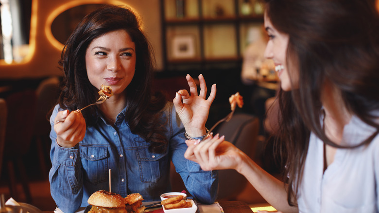 Two women eating food together