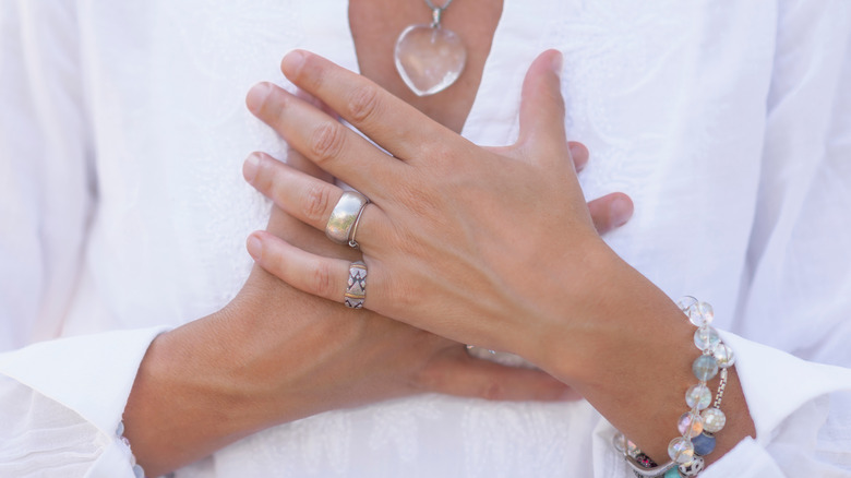 Woman meditating hands on chest