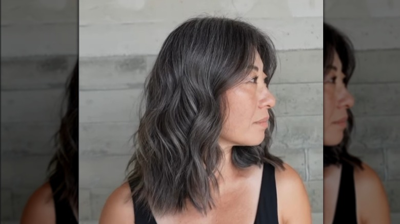 Woman with dark gray wavy lob