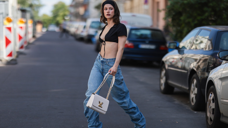 A woman wearing baggy jeans with a summery top