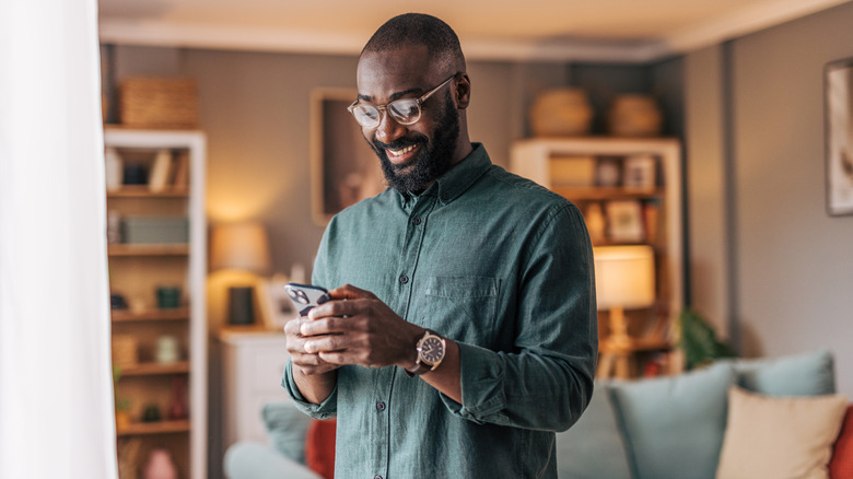A man holding a smartphone while smiling