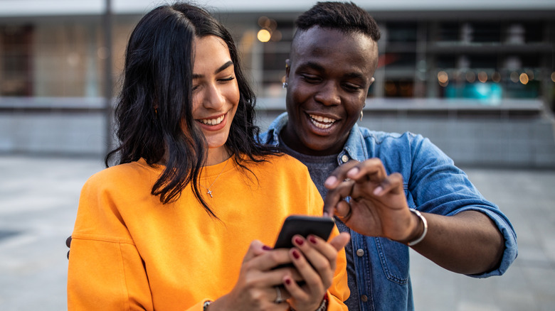 A cheerful couple looking at a smartphone screen