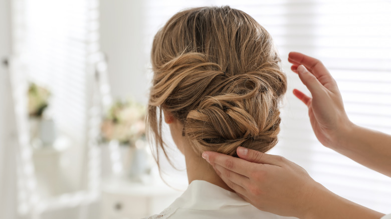 Stylist finishing chignon hairstyle