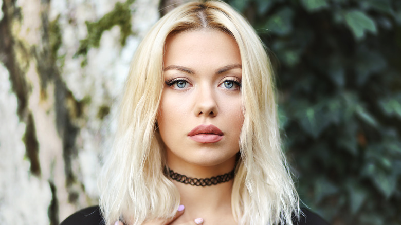A woman wearing a choker standing outdoors