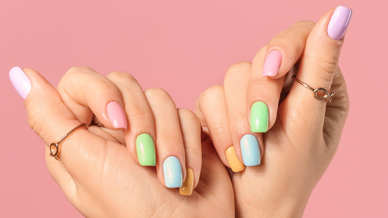 woman holding up hands with colorful manicure