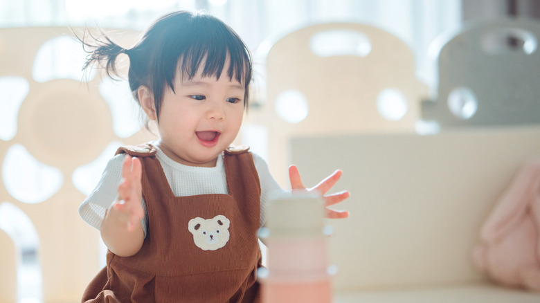 A happy baby playing with toys