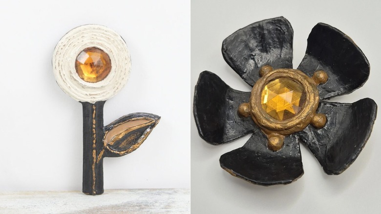Paper mache flower brooch designed by Enid Collins in the 1960s (L) and black paper mache brooch pin designed by Enid Collins in the 1960s (R)