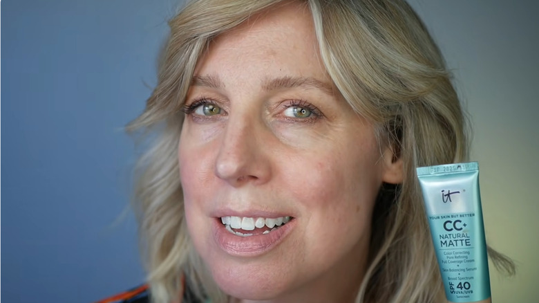 Close up image of a woman holding a tube of IT Cosmetics CC cream.
