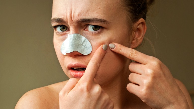 Woman examining her skin in the mirror