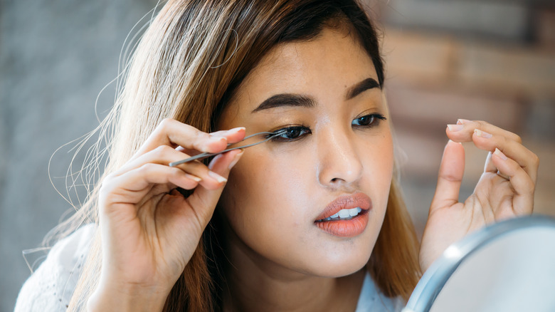 Woman applying fake eyelashes