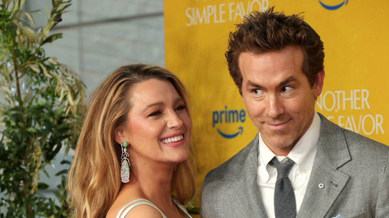 Ryan Reynolds on the red carpet with a funny face next to Blake Lively.