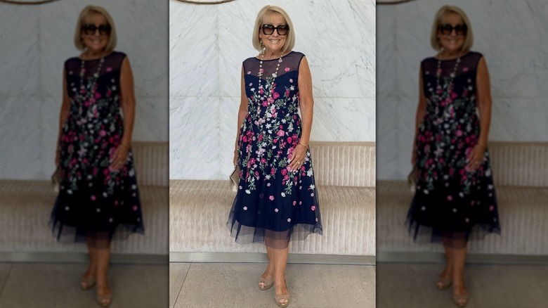older woman wearing a floral dress with a sheer overlay