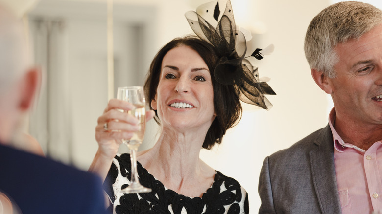 A mature wedding guest toasting with champagne