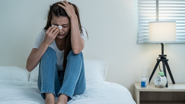 Woman crying in her bed