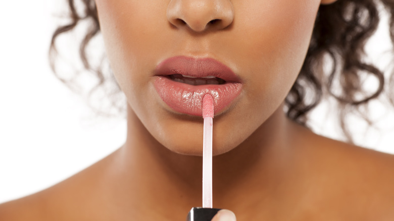 woman applying lip gloss