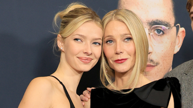 Apple Martin and Gwyneth Paltrow pose with their heads pressed against each other's while attending a red carpet event.