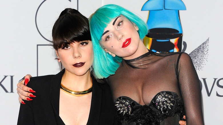 Lady Gaga wears a bright turquoise wig while posing next to sister Natali Germanotta on the red carpet