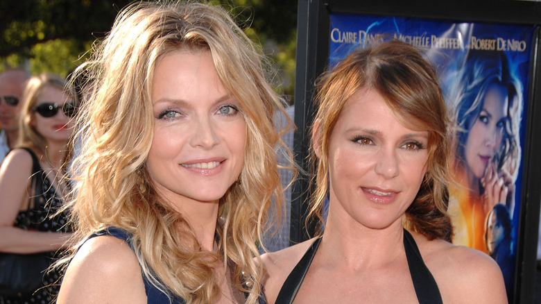 Michelle Pfeiffer and her sister Dedee Pfeiffer pose together outdoors at a movie premiere.