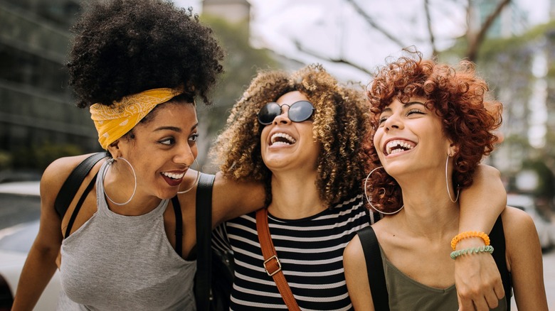 three women laughing and hugging