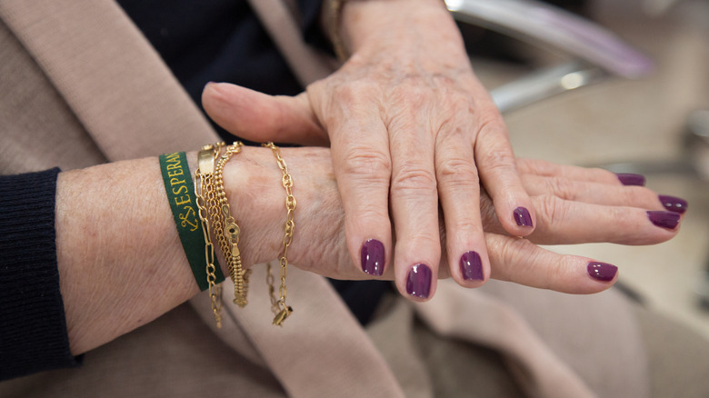 A woman with dark purple nails.