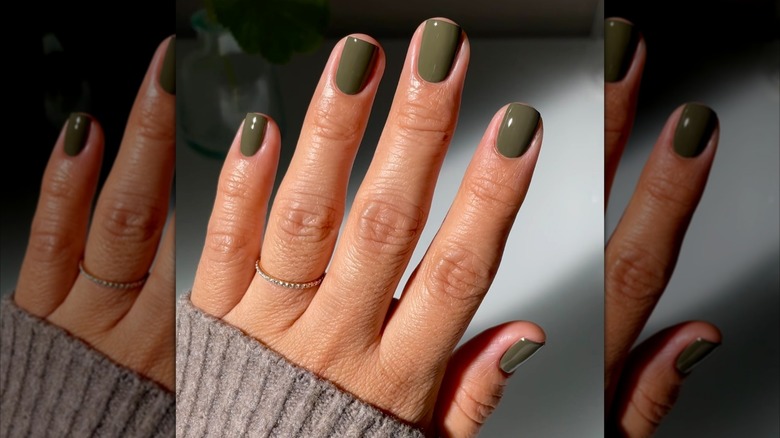 Close up shot of an olive-green manicure.