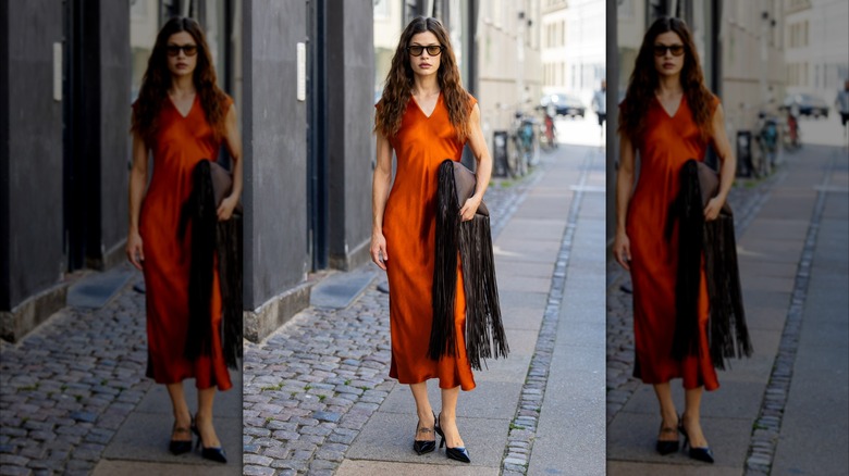 A woman wearing a burnt orange satin dress.