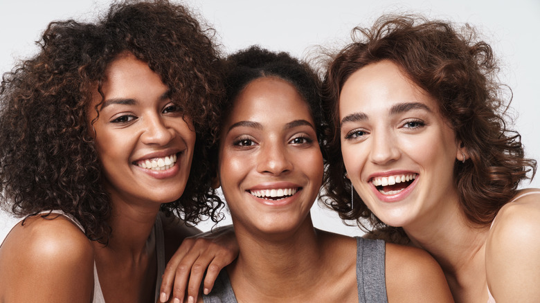 Three woman close together smiling