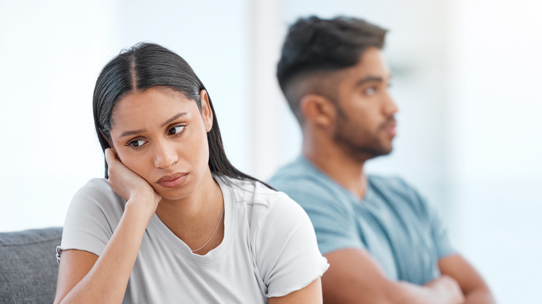 Woman looking away from man on couch