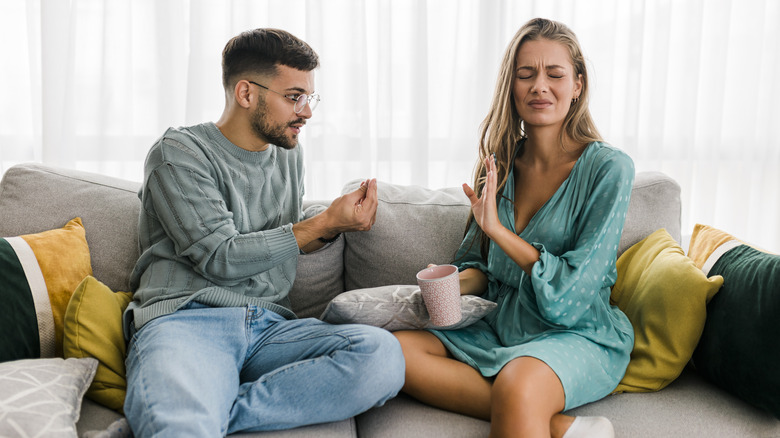 Annoyed woman on couch with partner