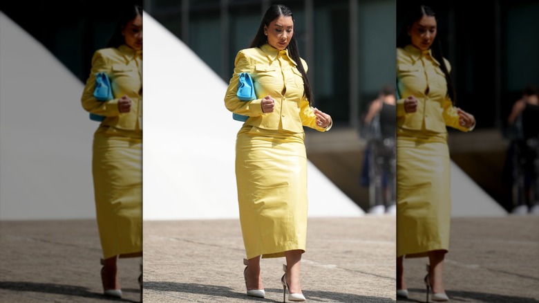 A woman in a yellow dress and pencil skirt
