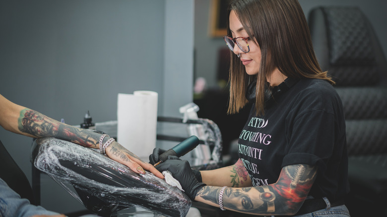 tattoo artist sitting with client