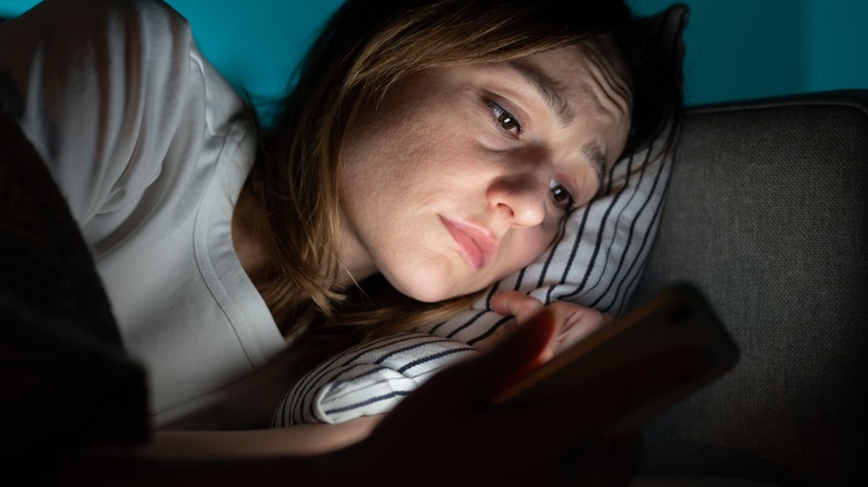 Woman looking brokenhearted in bed