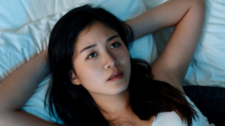 Worried Asian girl in bed