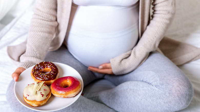 Pregnant woman eating donuts