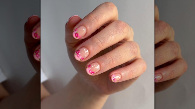 Nails with flowers on them in a varied pink palette