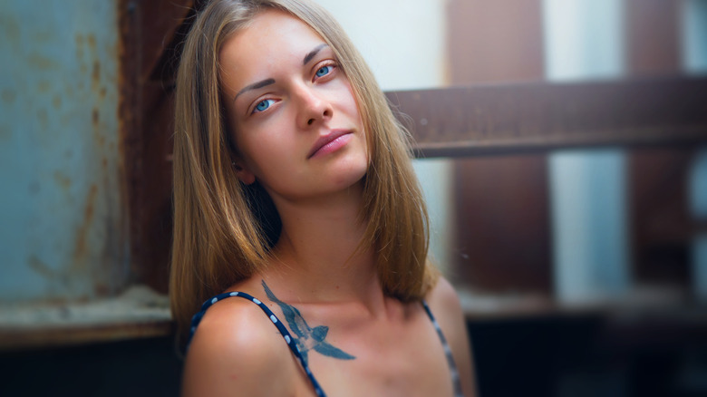 woman standing with collarbone tattoo